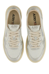 A pair of autry women medalist low sneakers in white and silver metallic with perforated uppers and cream laces