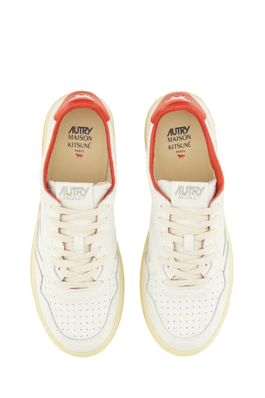 White leather autry women’s medalist low sneaker with orange accents and perforated detailing