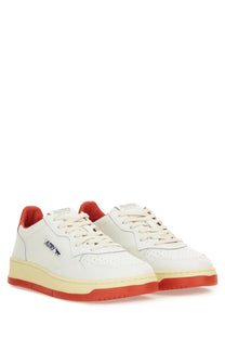 Autry women’s medalist low sneaker in white leather with red heel and sole accents and cream midsole visible from back