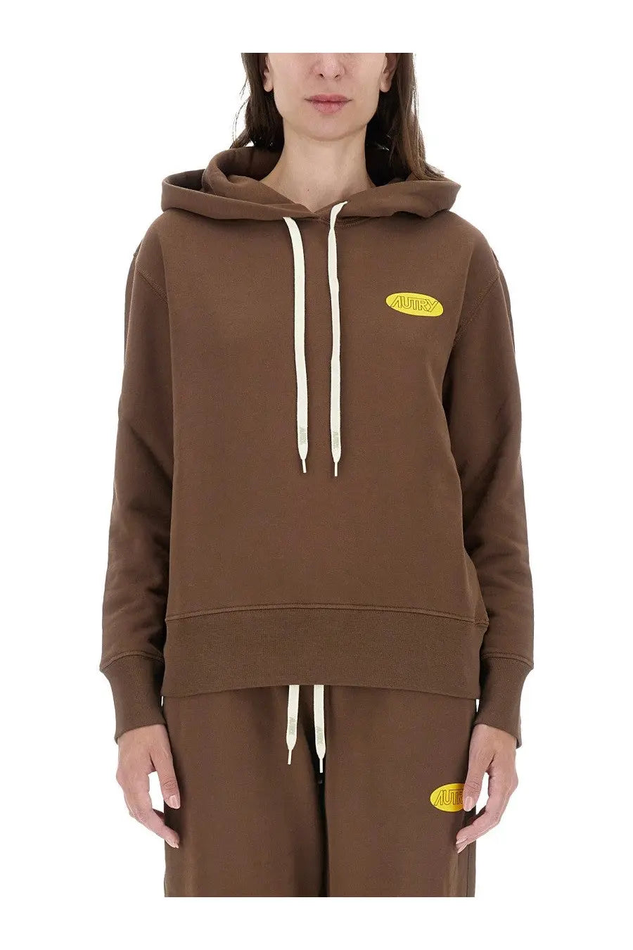 Brown hooded sweatshirt with cream drawstrings and yellow oval logo on chest from AUTRY women’s collection