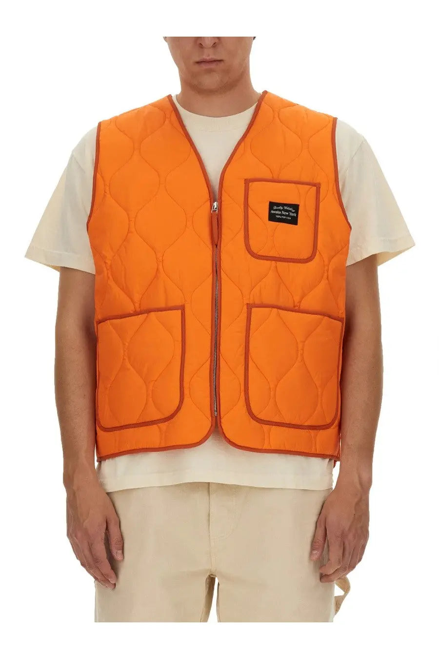 Awake Ny men’s bright orange quilted vest with central zipper three pockets and red stitching along seams