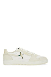 Cream-colored suede and canvas low-top sneaker with embroidered bird design on the side by Axel Arigato