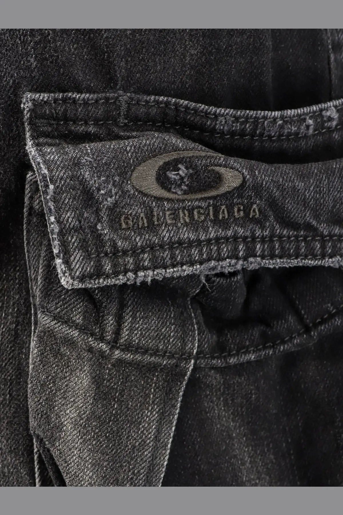 Balenciaga men’s cargo black denim trousers in dark gray distressed denim with visible brand label on back pocket