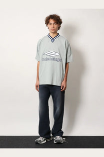Light gray balenciaga oversized cotton t-shirt with white logo and navy blue collar trim paired with blue men’s jeans