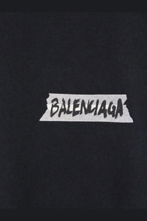 Balenciaga men’s black cotton t-shirt featuring a white tape-sticker logo with bold black lettering