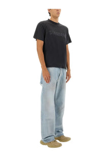 Black short-sleeved t-shirt with faded standard print across the chest paired with balenciaga men’s deconstructed jeans blue