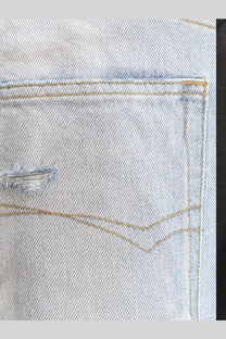 Balenciaga men’s distressed light-wash denim jeans pocket with frayed tear and contrasting tan stitching back side