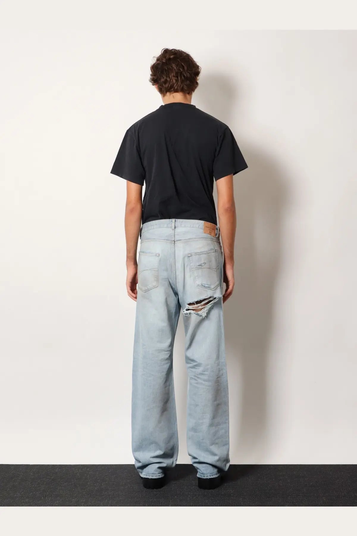 Balenciaga men’s light-wash denim jeans in blue with distressed ripped knee detail for casual wear