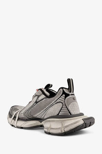 Back view of balenciaga men’s grey mesh sneakers with black mesh and chunky sole featuring balenciaga logo on heel