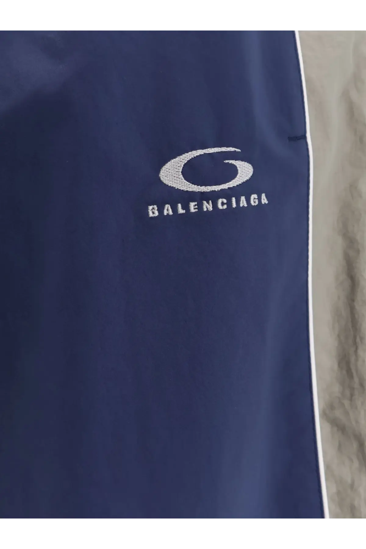 Balenciaga men’s navy blue sporty nylon track pants with white embroidered logo and side stripe