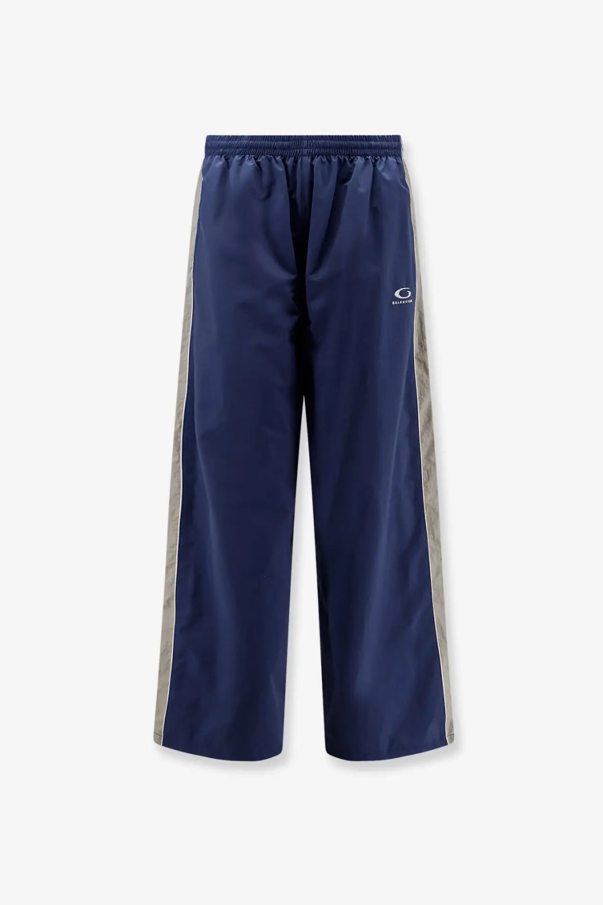 Balenciaga men’s sporty nylon navy blue track pants with silver side stripes and small white logo on the thigh