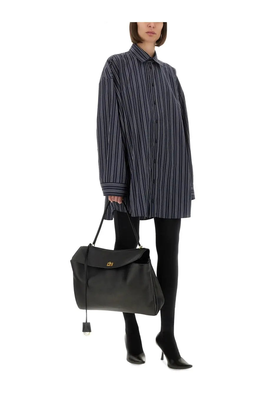 Balenciaga black leather tote bag with gold tone logo clasp and dangling keychain complementing unisex oversize shirt blue