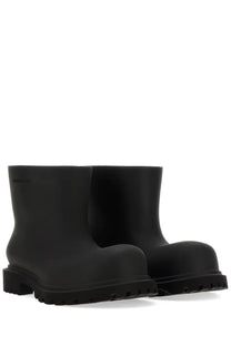 Balenciaga women’s black rubber boots with chunky sole and minimalist design shown from the back side