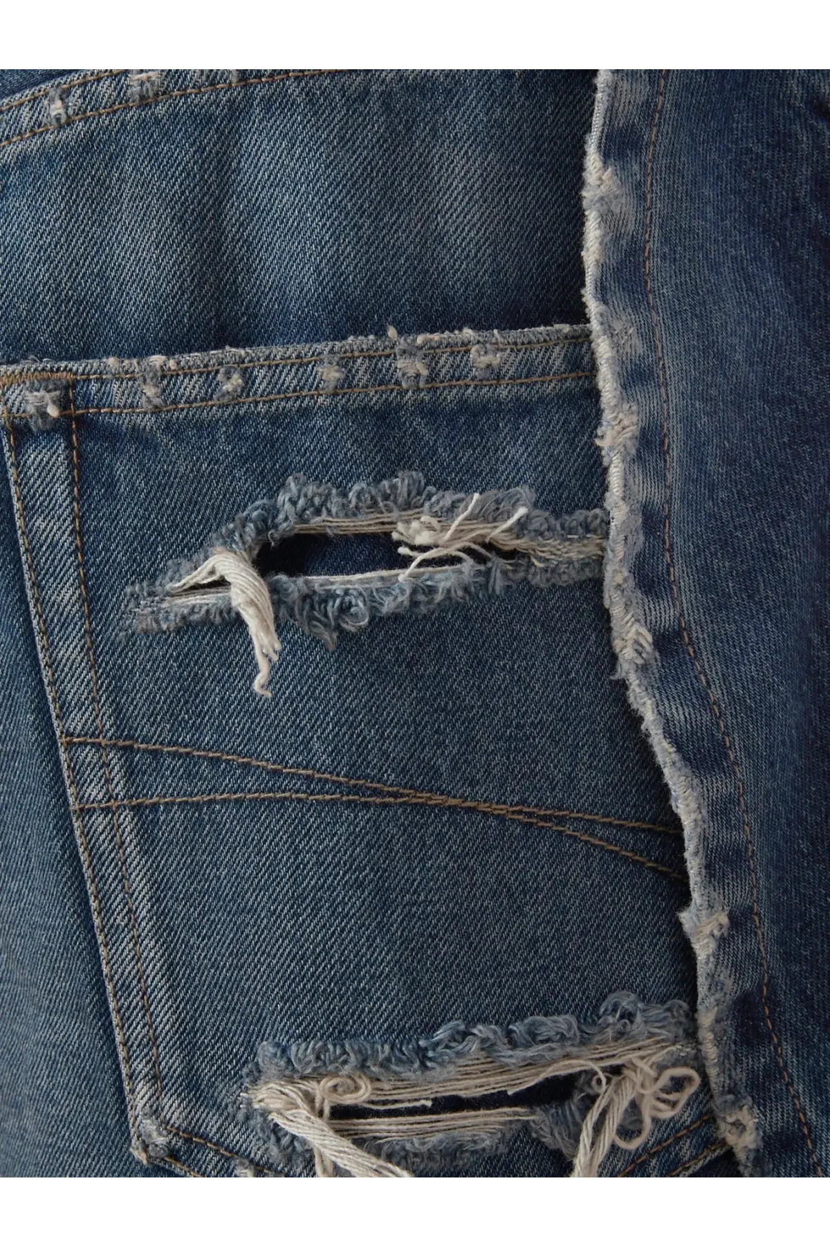 Balenciaga women’s cotton bermuda shorts in blue denim with distressed frayed rips and visible stitching details