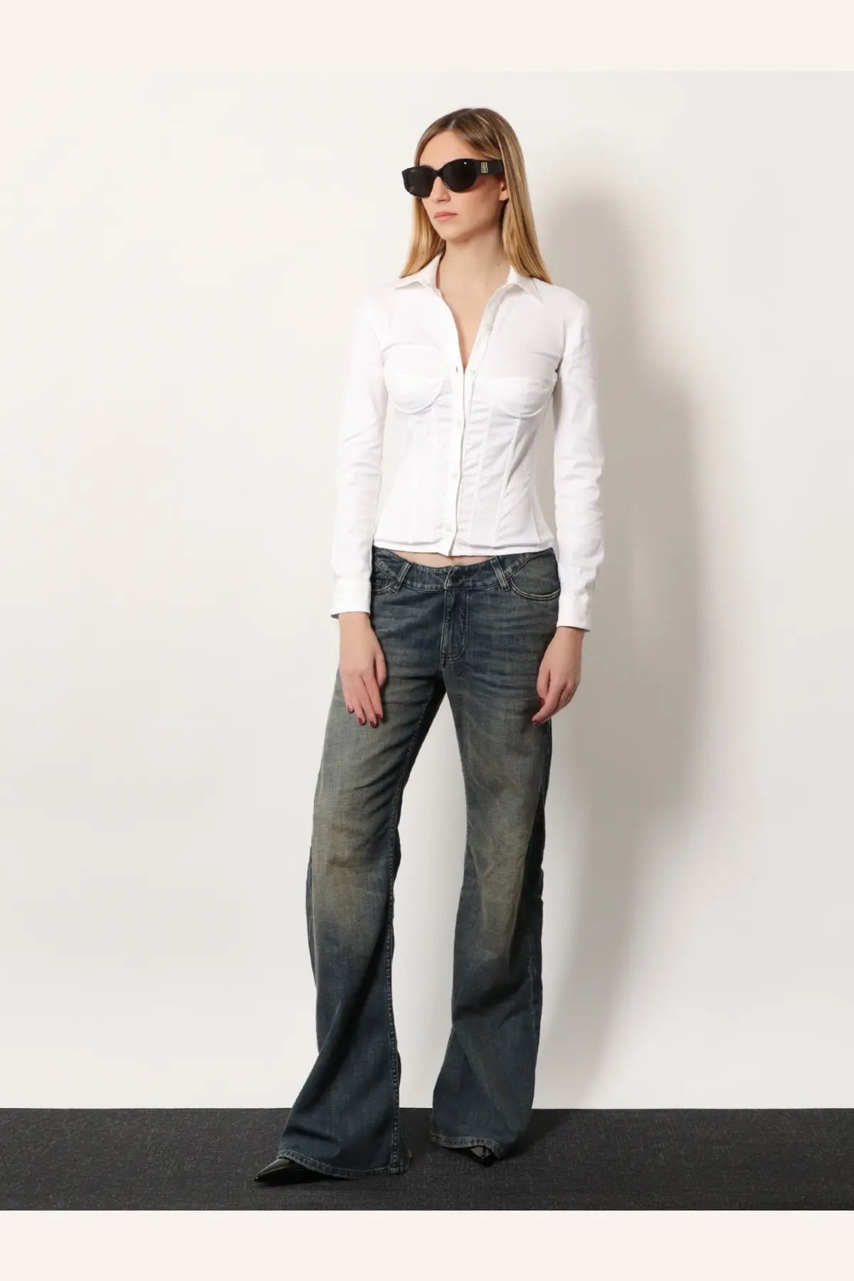 White button-up shirt with two front pockets and cropped hem paired with balenciaga curved waist blue jeans