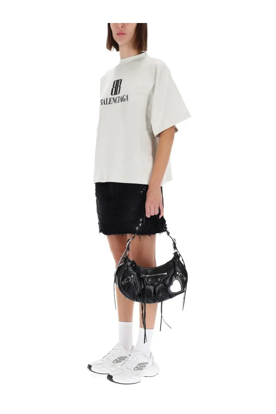 Black leather balenciaga bag with heart shaped cutouts and frayed detailing paired with balenciaga white shirt