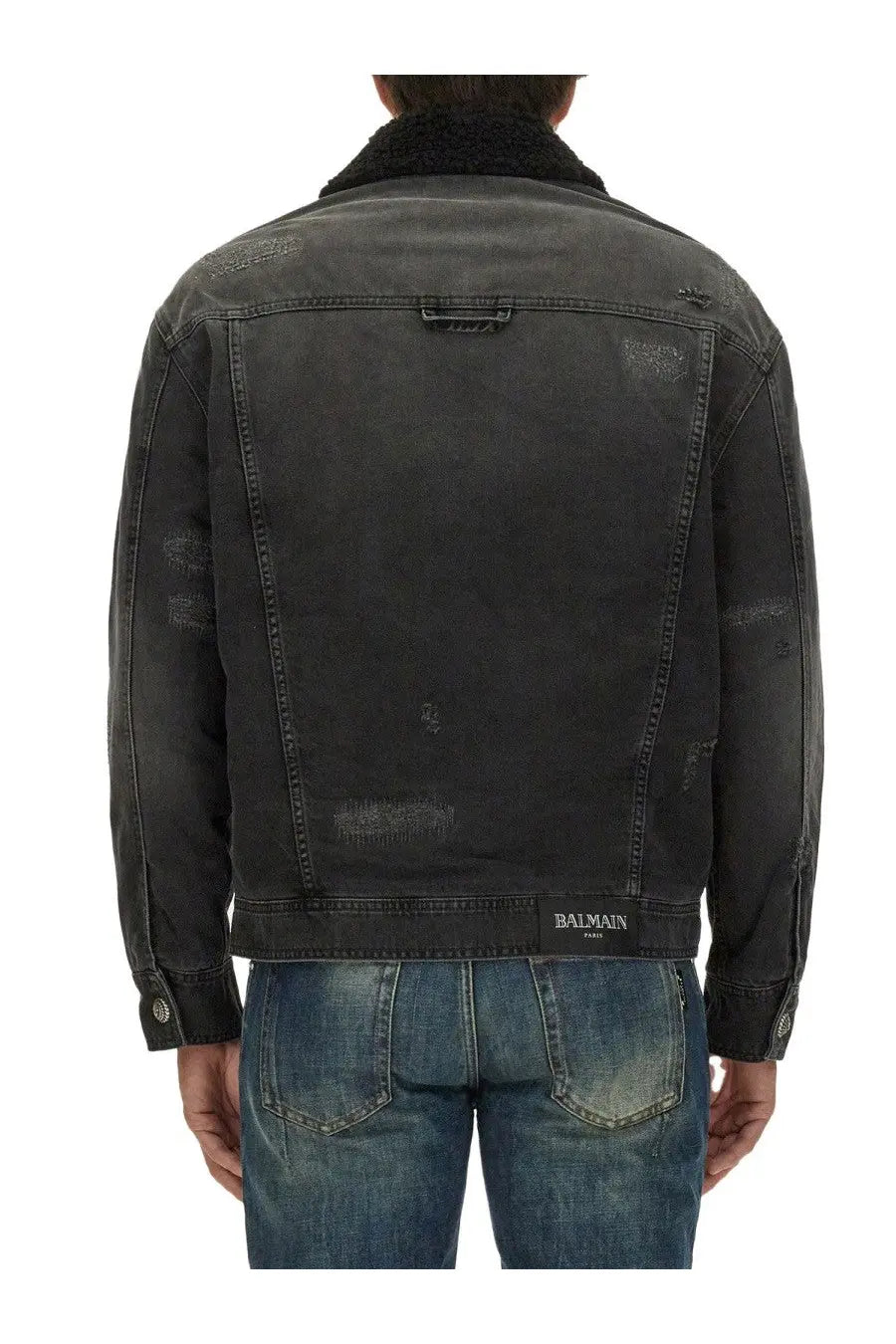 Balmain men’s destroyed black denim jacket with distressed details, plush shearling collar, and Balmain Paris waistband label