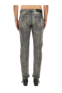 Balmain men’s regular fit grey distressed denim jeans with subtle pattern and black waistband label visible from front