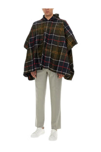 Barbour men’s poncho in dark green and black plaid with white red and yellow lines and a hood