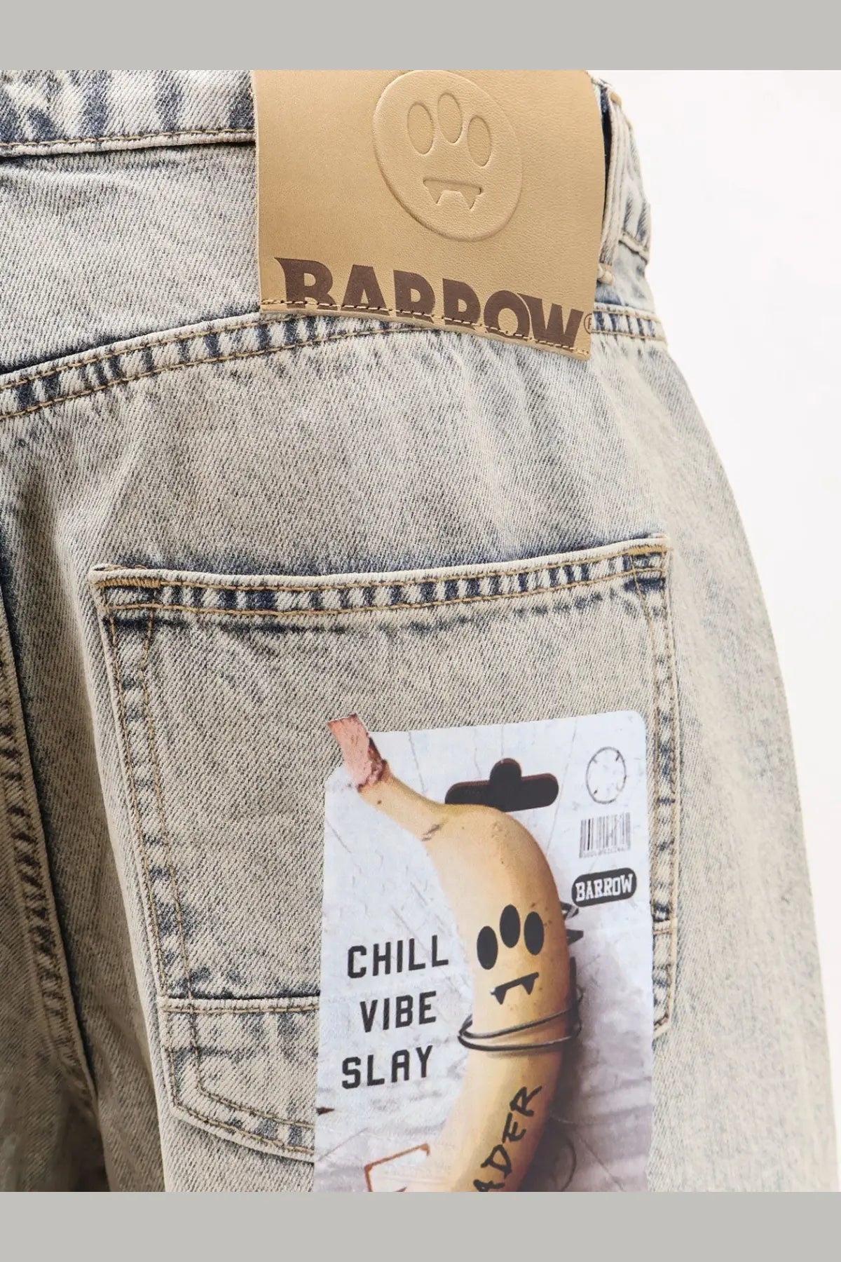 Light-wash barrow men’s cotton jeans in blue with brown leather brand tag and paw print logo on back waistband