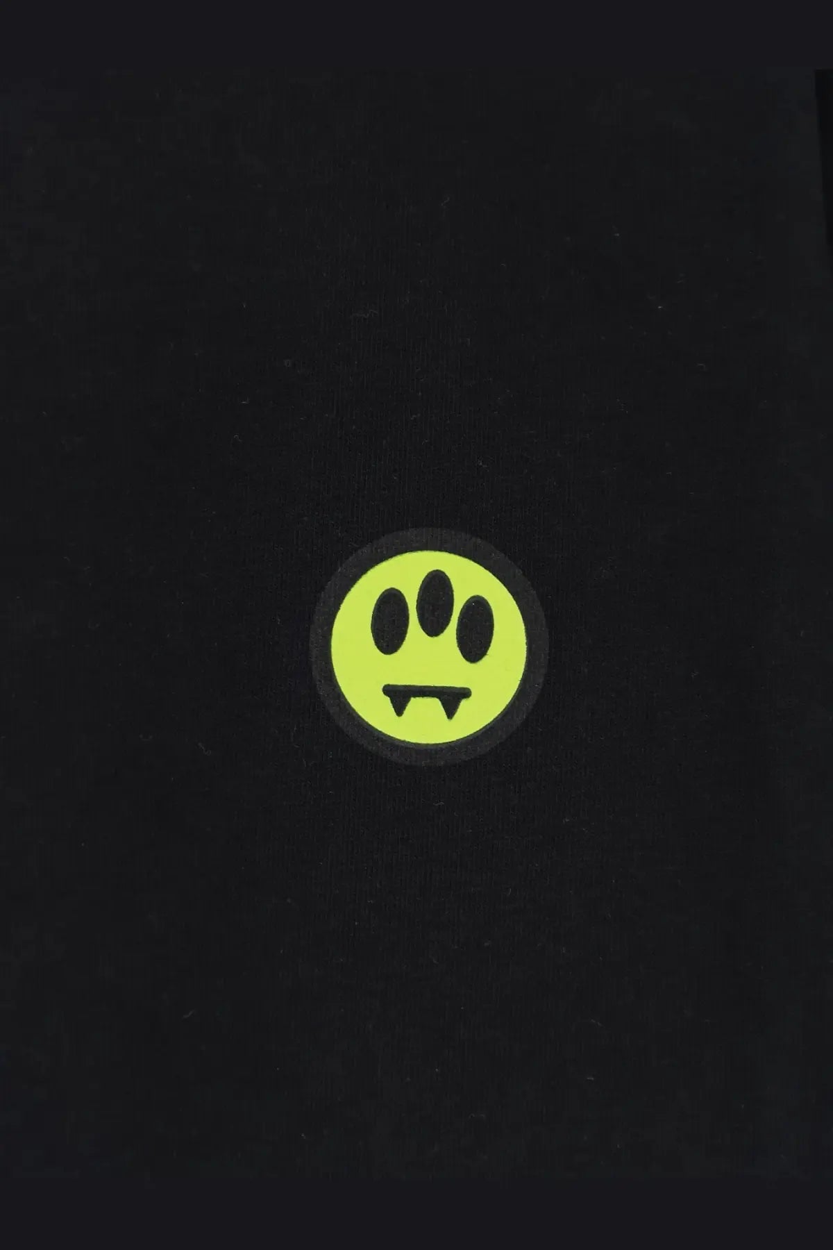 Neon green paw print sticker on black barrow men’s cotton shirt highlighting unique stylized design
