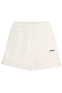 Cream-colored soft fabric barrow unisex bermuda iconic white shorts with elastic waistband and black logo on left leg
