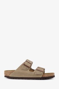 Beige suede birkenstock women’s arizona sandals with two adjustable straps and cork footbed in brown