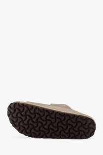 Beige birkenstock women’s arizona suede sandals with dark brown wavy-patterned rubber clog sole shown from back