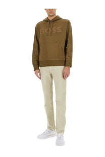 Boss men’s slim fit beige pants paired with an olive green hooded sweatshirt featuring a tonal brand logo on the chest