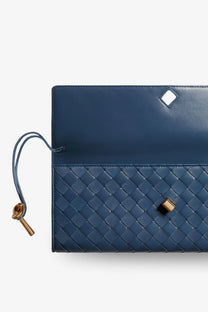 Deep blue leather clutch with woven texture and gold-tone hardware by bottega veneta women’s andiamo collection