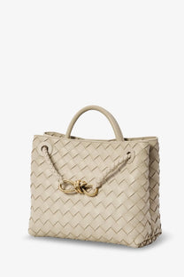 Beige woven leather tote bag with gold-tone bow clasp designed for women by bottega veneta
