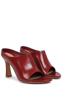 Red patent leather mules with a sleek glossy finish and block heel by bottega veneta women’s mule shoe frog red
