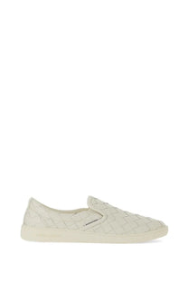 Cream-colored woven leather slip-on sneaker with minimalist design and subtle branding on the side by Bottega Veneta