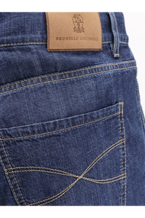 Dark blue cotton denim jeans with tan leather brunello cucinelli brand patch on the back waistband