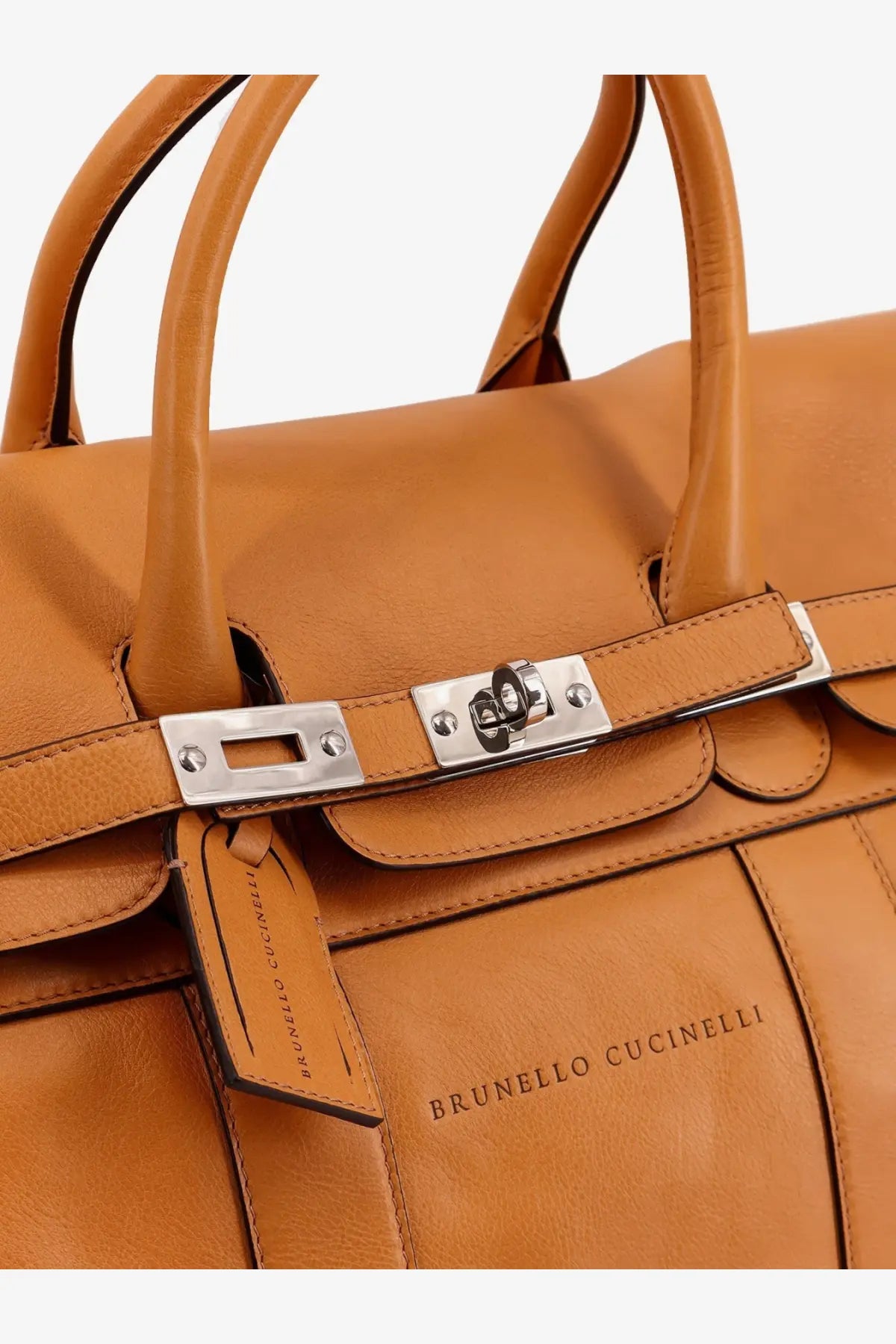 Tan leather Brunello Cucinelli men’s travel bag with silver toned hardware and branded tag in white background