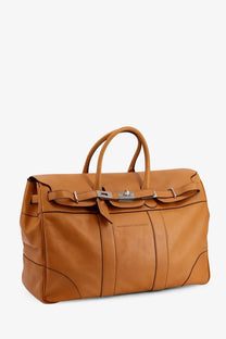 Brunello Cucinelli men’s tan leather travel bag with silver hardware and distinctive front clasp design