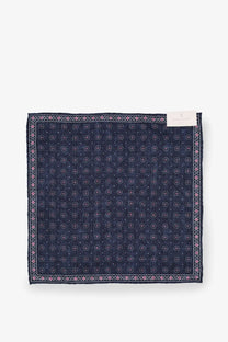 A brunello cucinelli men’s silk pocket square in navy blue with a subtle pink and white geometric pattern and ornate border