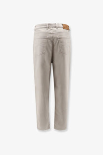 Back side of brunello cucinelli men’s stretch canvas brown trousers showing beige denim jeans with classic pocket design and leather patch