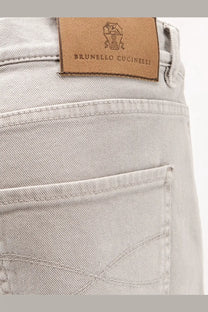 Light gray denim jeans with a brown leather brunello cucinelli brand patch on the back side