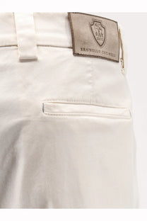 Cream-colored stretch cotton chino pants with a brunello cucinelli leather logo patch for men in white