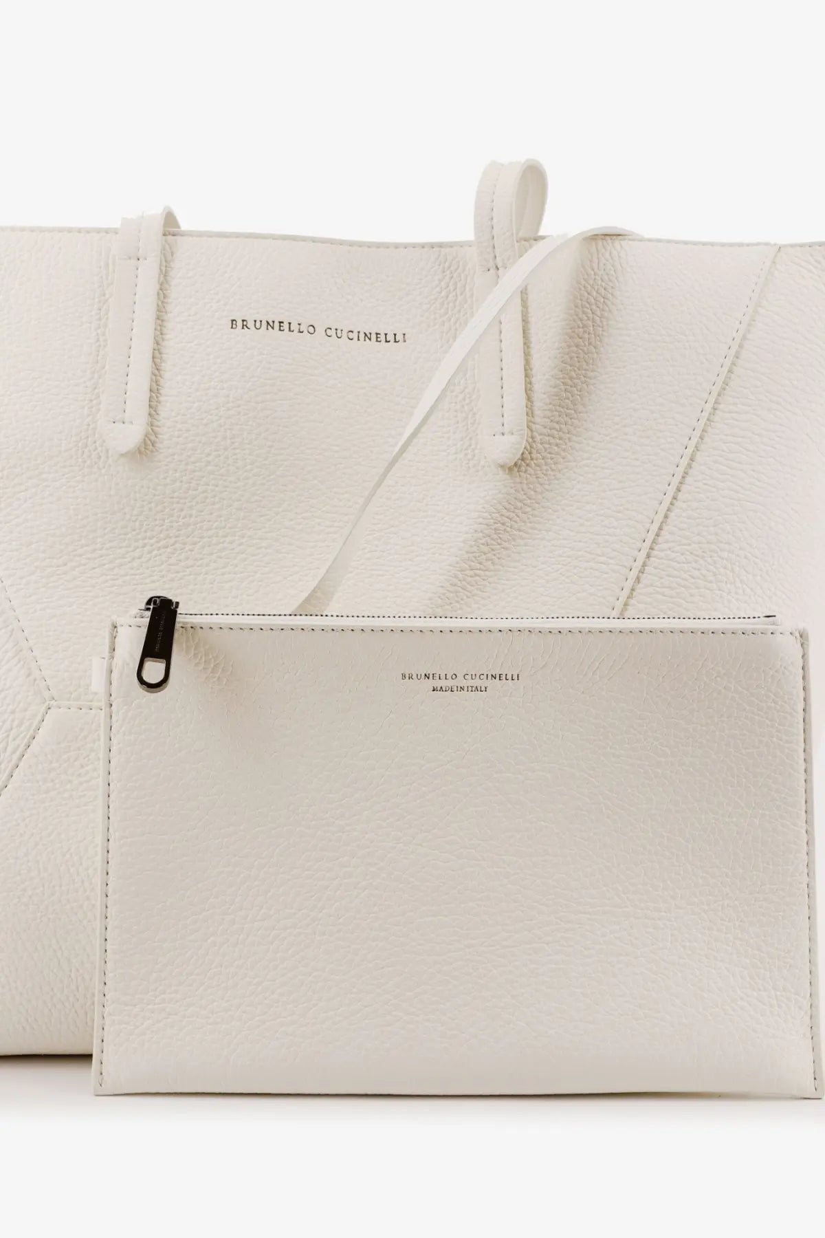 A sleek white leather clutch from Brunello Cucinelli with minimalist design and black zipper pull
