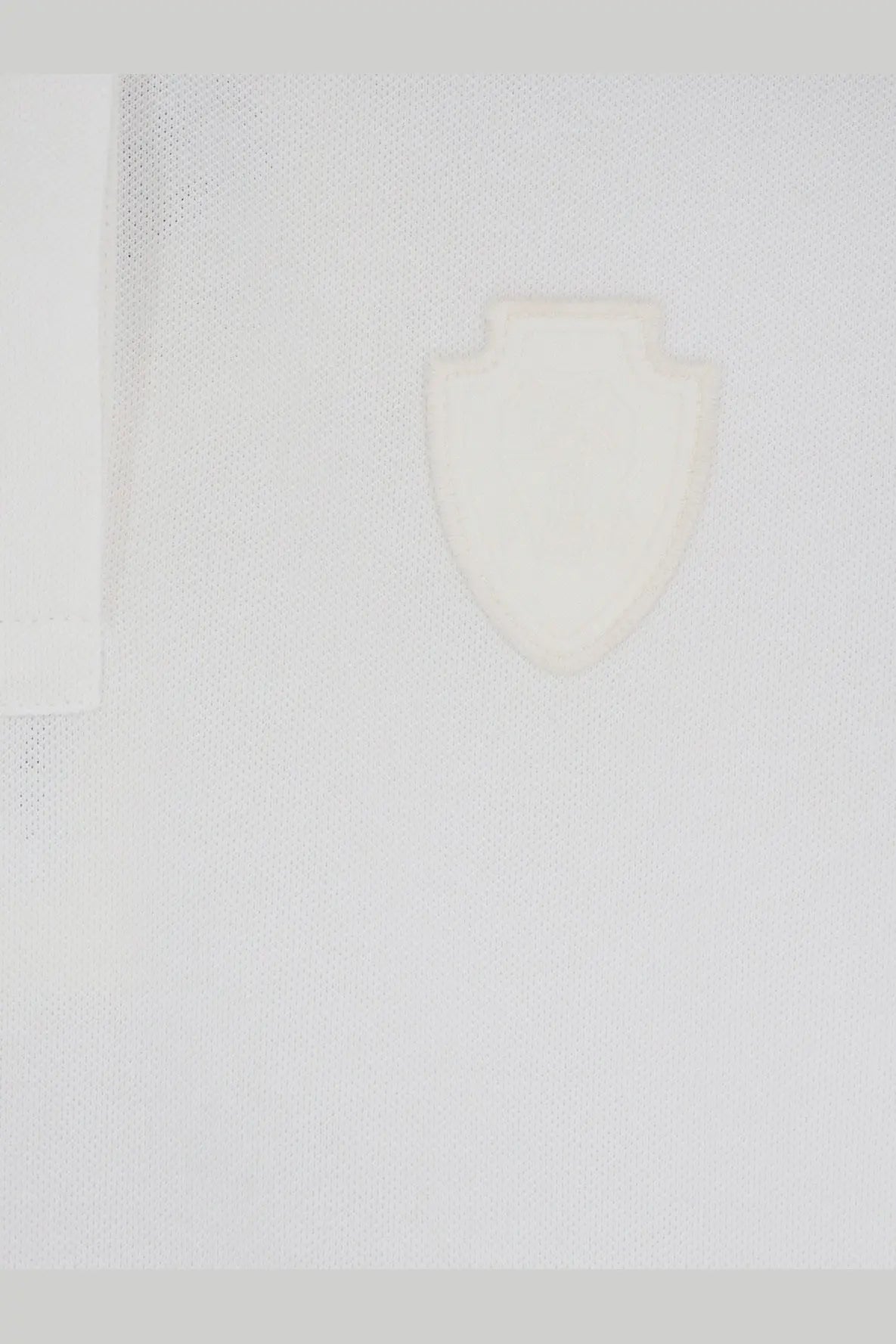 A minimalist white shield emblem embossed on textured fabric of brunello cucinelli women’s cotton blend white polo shirt