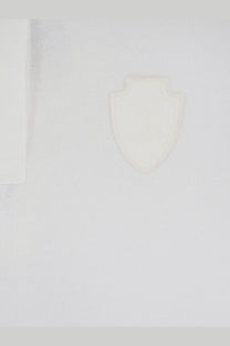 A minimalist white shield emblem embossed on textured fabric of brunello cucinelli women’s cotton blend white polo shirt