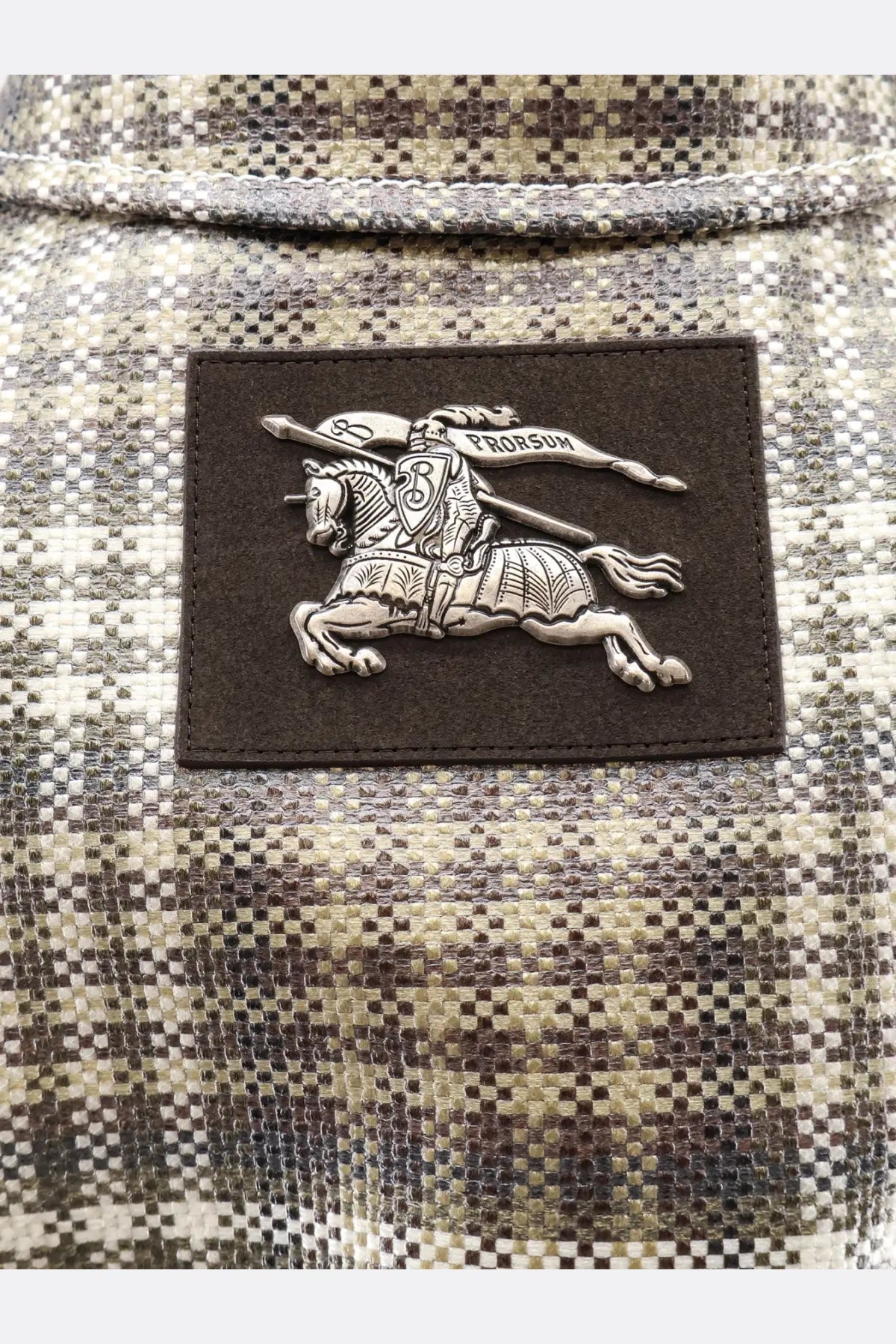 Burberry men’s foxfield madras trench white with silver embroidered knight patch on dark brown leather and plaid fabric background