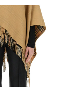 Beige woolen reversible Burberry women’s cape with fringed edges and classic check pattern inner lining