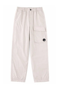Beige cargo pants by c.p. company with elastic waistband drawstring and large flap pocket with black button on thigh