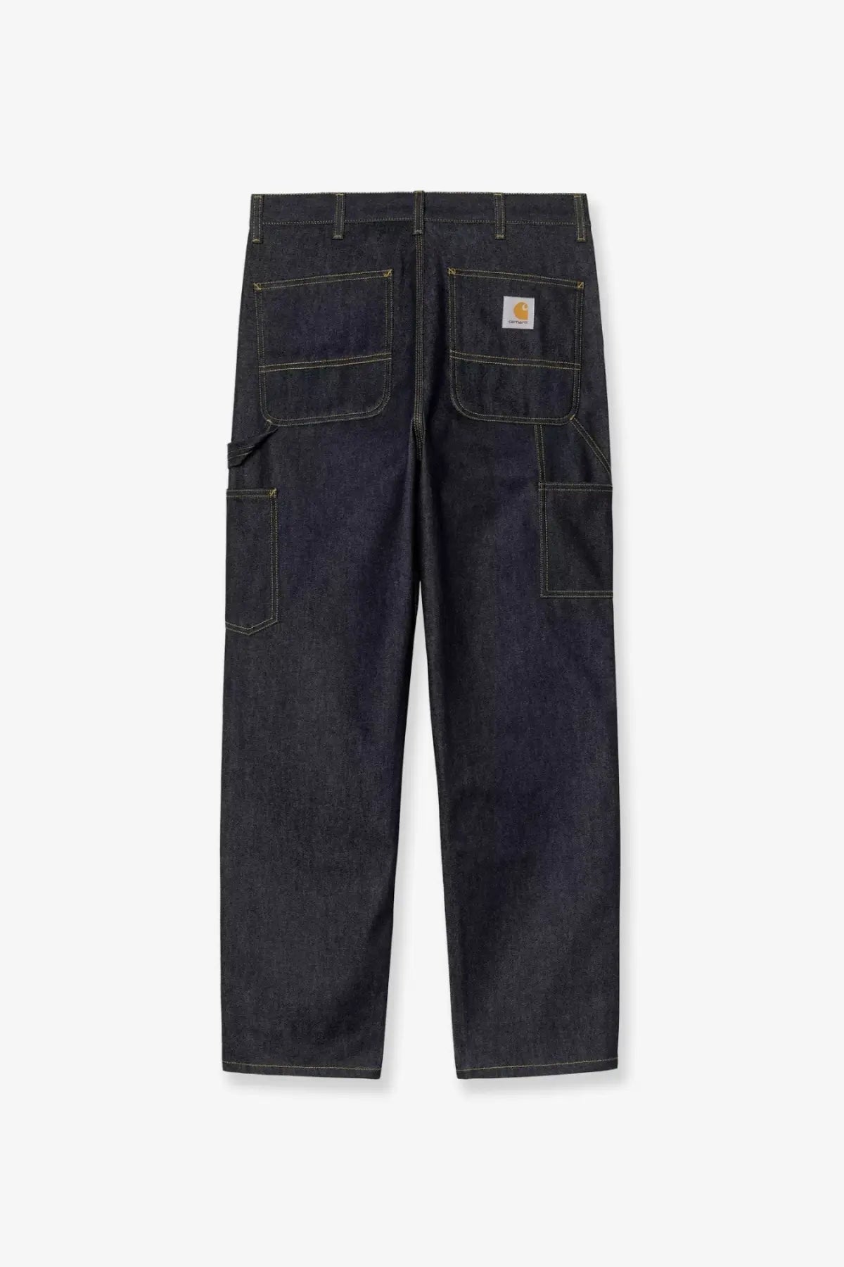 Dark indigo denim work pants with contrasting light stitching and carhartt logo patch on back right pocket showing back side
