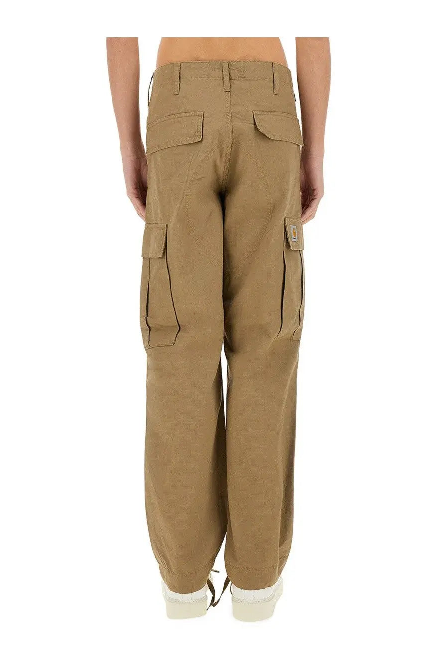Carhartt wip men’s beige cargo pants with multiple pockets and a visible brand patch on the thigh