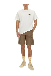 White crew neck cotton t-shirt with small green fish graphic paired with beige carhartt wip mens cotton bermuda shorts