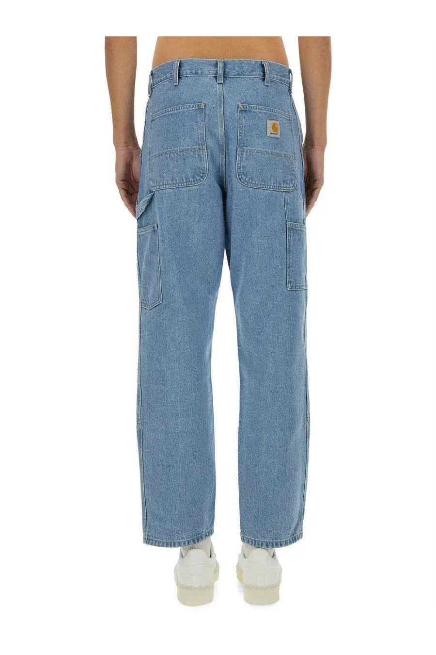 Back view of light-wash denim carhartt wip men’s double knee cargo pants with logo patch on back right pocket